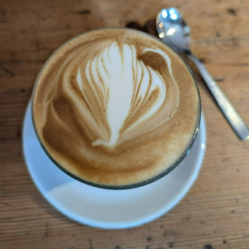 Ein kontrastreicher Cappuccino mit einem Pfau